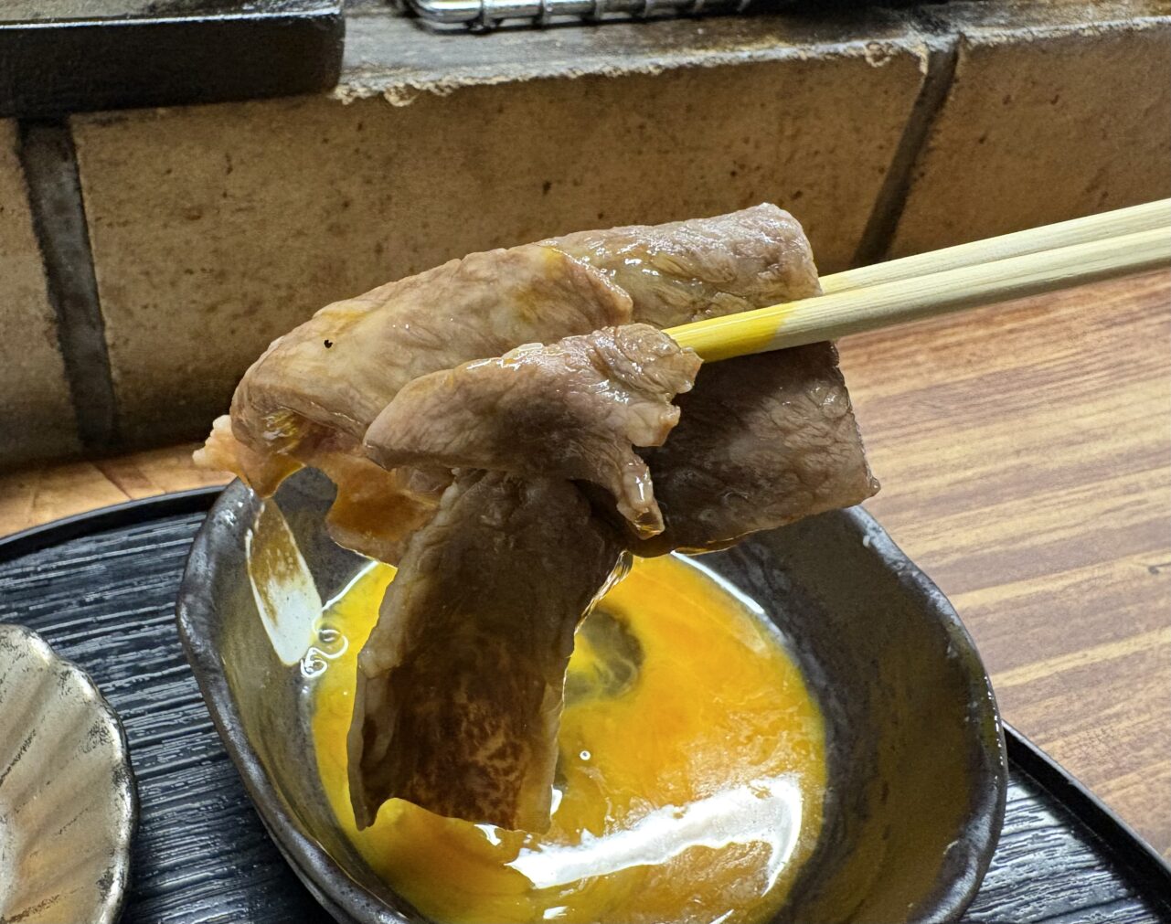 壱岐牛ロースを生卵にくぐらせる